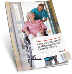 A healthcare professional wearing a stethoscope pushing an older woman in a wheelchair.